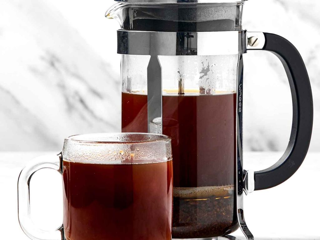 Immersion brewing concept illustrated with coffee grounds fully submerged in water